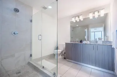 a bathroom with a glass shower and a toilet at Stunning Apartment in Downtown Doral in Miami