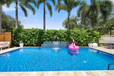 a swimming pool with a pink flamingo in the water at Palms Retreat! Giant Heated Pool-HotTub-FirePit-5Min2Beach-Pets-EV Chgr in Fort Lauderdale