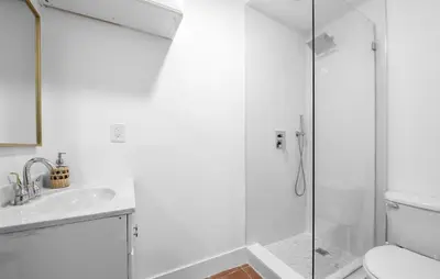 a white bathroom with a shower and a sink at Palms Retreat! Giant Heated Pool-HotTub-FirePit-5Min2Beach-Pets-EV Chgr in Fort Lauderdale