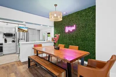 a kitchen and dining room with a green wall at Palms Retreat! Giant Heated Pool-HotTub-FirePit-5Min2Beach-Pets-EV Chgr in Fort Lauderdale
