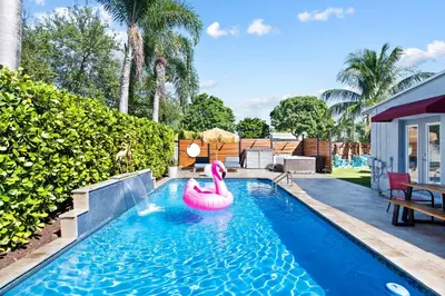 a swimming pool with a pink flamingo in the water at Palms Retreat! Giant Heated Pool-HotTub-FirePit-5Min2Beach-Pets-EV Chgr in Fort Lauderdale