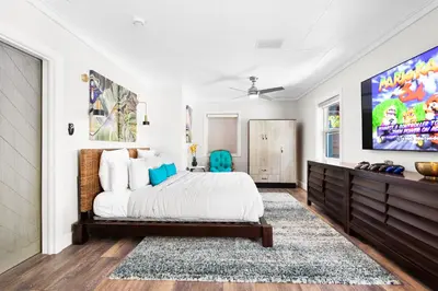 a bedroom with a large bed and a tv at Palms Retreat! Giant Heated Pool-HotTub-FirePit-5Min2Beach-Pets-EV Chgr in Fort Lauderdale