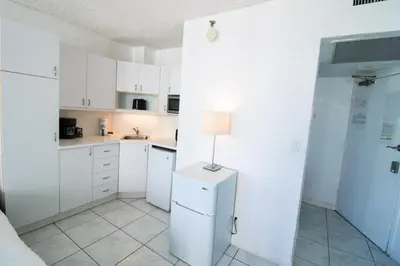 a kitchen with white cabinets and a lamp on a refrigerator at Castle 1118 Studio BayView Direct Beach Access, Tennis, Pool, Restaurants, Free Parking in Miami Beach