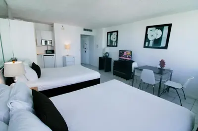 a room with two beds and a couch and a table at Castle 1118 Studio BayView Direct Beach Access, Tennis, Pool, Restaurants, Free Parking in Miami Beach