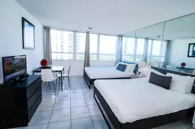 a hotel room with two beds and a table and a television at Castle 1118 Studio BayView Direct Beach Access, Tennis, Pool, Restaurants, Free Parking in Miami Beach