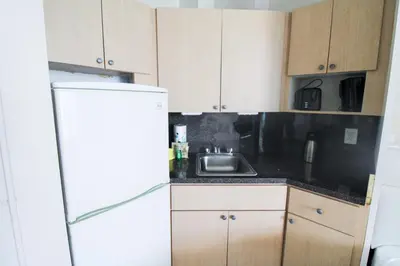 a kitchen with a sink and a refrigerator at Castle 1527 Studio Balcony Direct Beach Access, Pool, Tennis, Free Parking in Miami Beach
