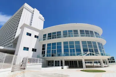 a large white building with blue sky in the background at Castle 1527 Studio Balcony Direct Beach Access, Pool, Tennis, Free Parking in Miami Beach