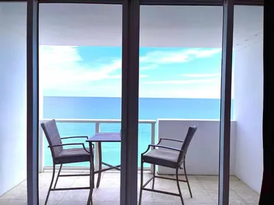 a table and two chairs on a balcony with the ocean at Castle 1527 Studio Balcony Direct Beach Access, Pool, Tennis, Free Parking in Miami Beach