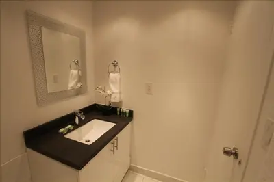 a bathroom with a sink and a mirror at Castle 515 Studio BayView Direct Beach Access, Pool, Tennis, Free Parking in Miami Beach
