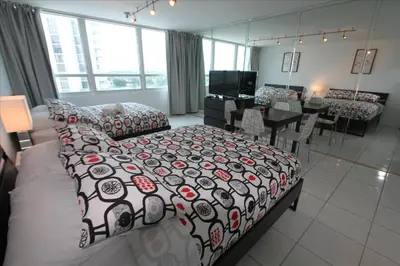 a bedroom with a bed and a dining room at Castle 515 Studio BayView Direct Beach Access, Pool, Tennis, Free Parking in Miami Beach