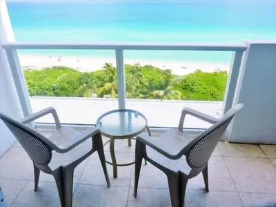 a table and chairs in a balcony with a view of the beach at Castle 727 Studio with balcony and Ocean view, Pool, Tennis, Beach Access, Free Parking in Miami Beach