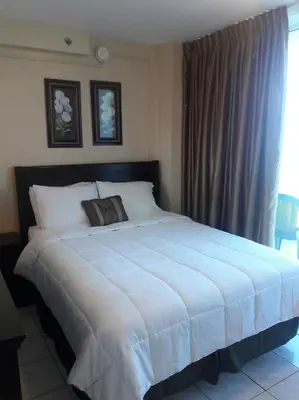 a bedroom with a large white bed with a window at Castle 727 Studio with balcony and Ocean view, Pool, Tennis, Beach Access, Free Parking in Miami Beach