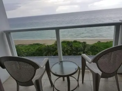 a balcony with a table and chairs and the ocean at Castle 727 Studio with balcony and Ocean view, Pool, Tennis, Beach Access, Free Parking in Miami Beach