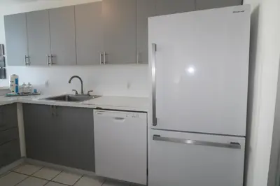 a white kitchen with a refrigerator and a sink at Castle B6 in Miami Beach