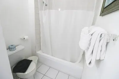 a white bathroom with a tub and a toilet at Castle B6 in Miami Beach