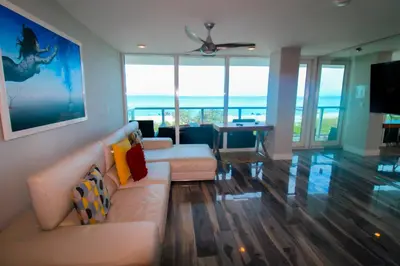 a living room with two couches and a television at Castle BTH2 Stunning Oceanfront Townhouse, Private Beach Access, Private Pool Access, Tennis and Free Parking! in Miami Beach