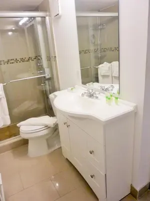 a white bathroom with a toilet and a sink at Castle M4 Beachfront Balcony Loft, FREE Parking, Pool, Tennis, Beach Access in Miami Beach