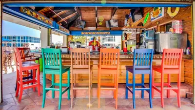 a group of colorful chairs sitting at a bar at Castle M4 Beachfront Balcony Loft, FREE Parking, Pool, Tennis, Beach Access in Miami Beach