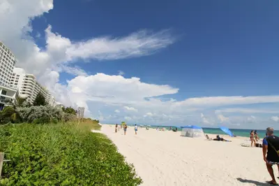 a group of people walking on the beach at Castle PH12 Spacious Bay View Penthouse, Pool, Tennis, Free Parking in Miami Beach