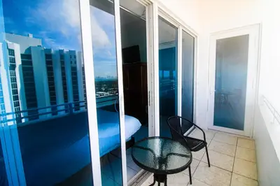 a balcony with a table and a chair on a building at Castle PH12 Spacious Bay View Penthouse, Pool, Tennis, Free Parking in Miami Beach