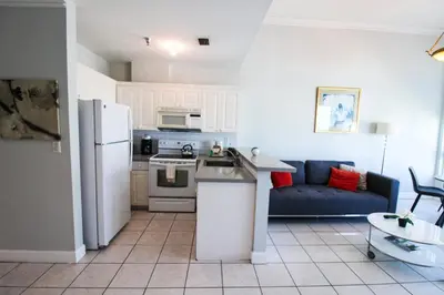 a kitchen and living room with a refrigerator and a couch at Castle PH12 Spacious Bay View Penthouse, Pool, Tennis, Free Parking in Miami Beach