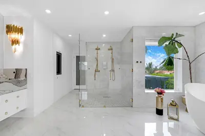 a white bathroom with a shower and a sink at MIA MANSION W/ POOL / BBQ /CABANNA / OUTDOOR BAR in Tamiami
