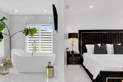 a bedroom with a bath tub next to a bed at MIA MANSION W/ POOL / BBQ /CABANNA / OUTDOOR BAR in Tamiami