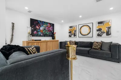 a living room with two couches and a tv at MIA MANSION W/ POOL / BBQ /CABANNA / OUTDOOR BAR in Tamiami