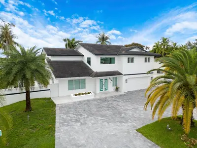 a white house with palm trees in front of it at MIA MANSION W/ POOL / BBQ /CABANNA / OUTDOOR BAR in Tamiami