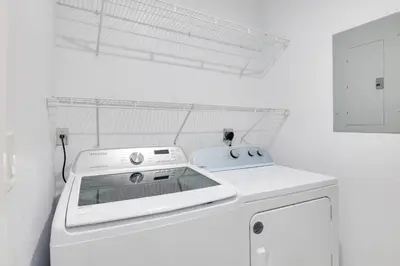 a white kitchen with a stove and a dishwasher at Luxe Miami Home Outdoor Kitchen, Gas Grill! in Miami Gardens
