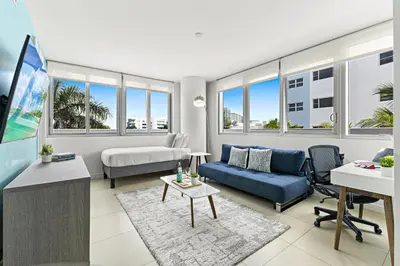 a living room with a couch and a bed at Dharma Home Suites Miami Beach at Monte Carlo in Miami Beach