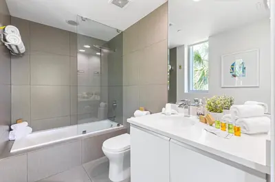 a bathroom with a sink and a toilet and a tub at Dharma Home Suites Miami Beach at Monte Carlo in Miami Beach
