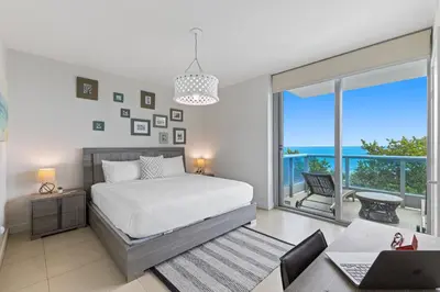a bedroom with a bed and a view of the ocean at Dharma Home Suites Miami Beach at Monte Carlo in Miami Beach