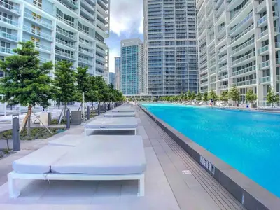 a swimming pool with chaise lounges next to tall buildings at ICON W BRICKELL BY IMD MIAMI Splendid Ocean View 2BR 1BA in Miami