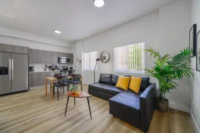 a living room with a blue couch and a kitchen at Charming Apt Near to Stadium LoanDepot Park in Miami