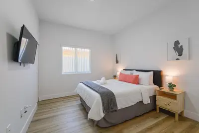 a bedroom with a bed and a tv on a wall at Charming Apt Near to Stadium LoanDepot Park in Miami