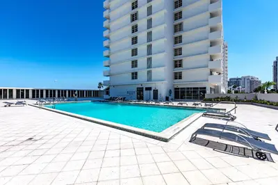 a swimming pool in front of a building at Pavilion Residences on the Beach in Miami Beach