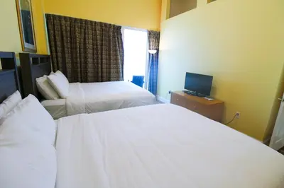 a hotel room with two beds and a television at Castle Ph2 Balcony Oceanfront Condo, Beach Access, Pool, Tennis, Free Parking in Miami Beach