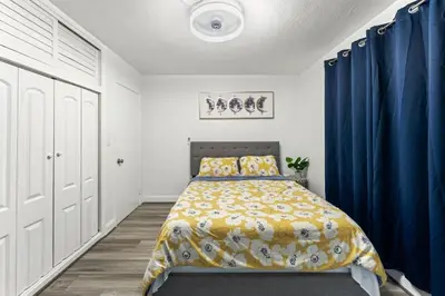 a bedroom with a bed with blue curtains in it at Sunrise Getaway in Sunrise