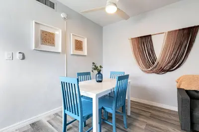 a dining room with a white table and blue chairs at Mia Airport 1b Apt with desk Virg 9 in Miami