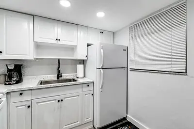 a kitchen with white cabinets and a white refrigerator at Central 1b apt Next to Airport Virg 12 in Miami