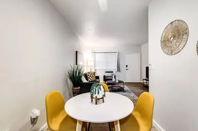 a living room with a white table and yellow chairs at Spacious 2 BR near Miami Airport Virg 5 in Miami