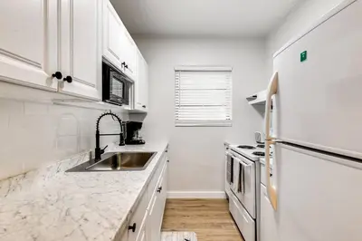 a white kitchen with a sink and a refrigerator at Spacious 2 BR near Miami Airport Virg 5 in Miami