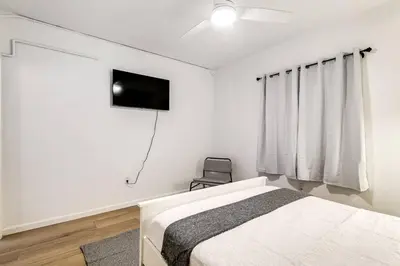 a bedroom with a bed and a flat screen tv at Miami Airport 2-bedroom unit with speedy Wi-Fi Virg8 in Miami