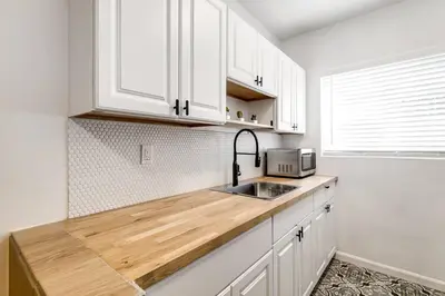 a kitchen with white cabinets and a sink at Miami Airport 2-bedroom unit with speedy Wi-Fi Virg8 in Miami