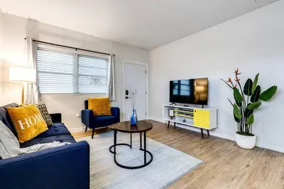 a living room with a blue couch and a tv at Stylish 2BR central Fast Wi fi virg2 in Miami