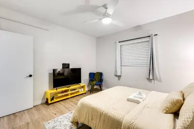a bedroom with a bed and a flat screen tv at Stylish 2BR central Fast Wi fi virg2 in Miami