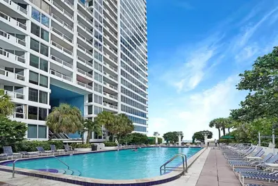 a swimming pool in front of a tall building at Star Dust! Heart of Miami Dream Stay! 4 BR in Miami