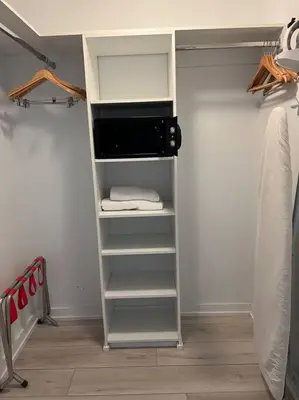 a walk in closet with a microwave and towels at Beach Retreat, Sleek Design & Full Kitchen -A in Hallandale Beach