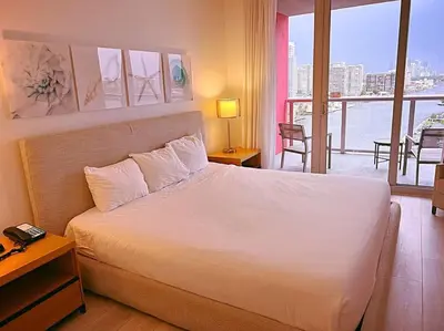 a bedroom with a white bed with a view of the water at Sun, Sand & Views 1BR Apartment in Miami Beach in Hallandale Beach